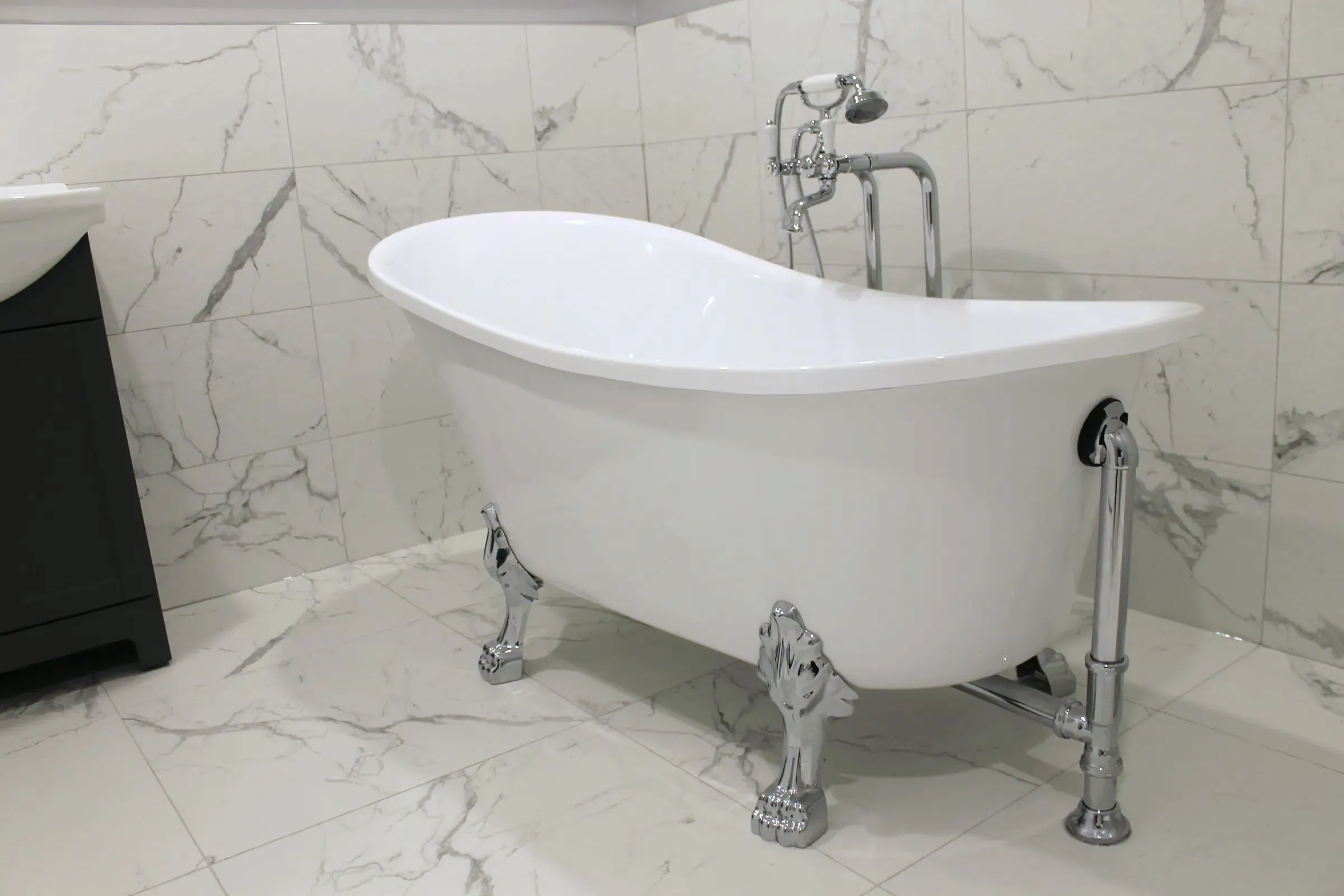 Finished bathroom with a white clawfoot tub and stone-look tile, by ToughJobs in Greater Montreal